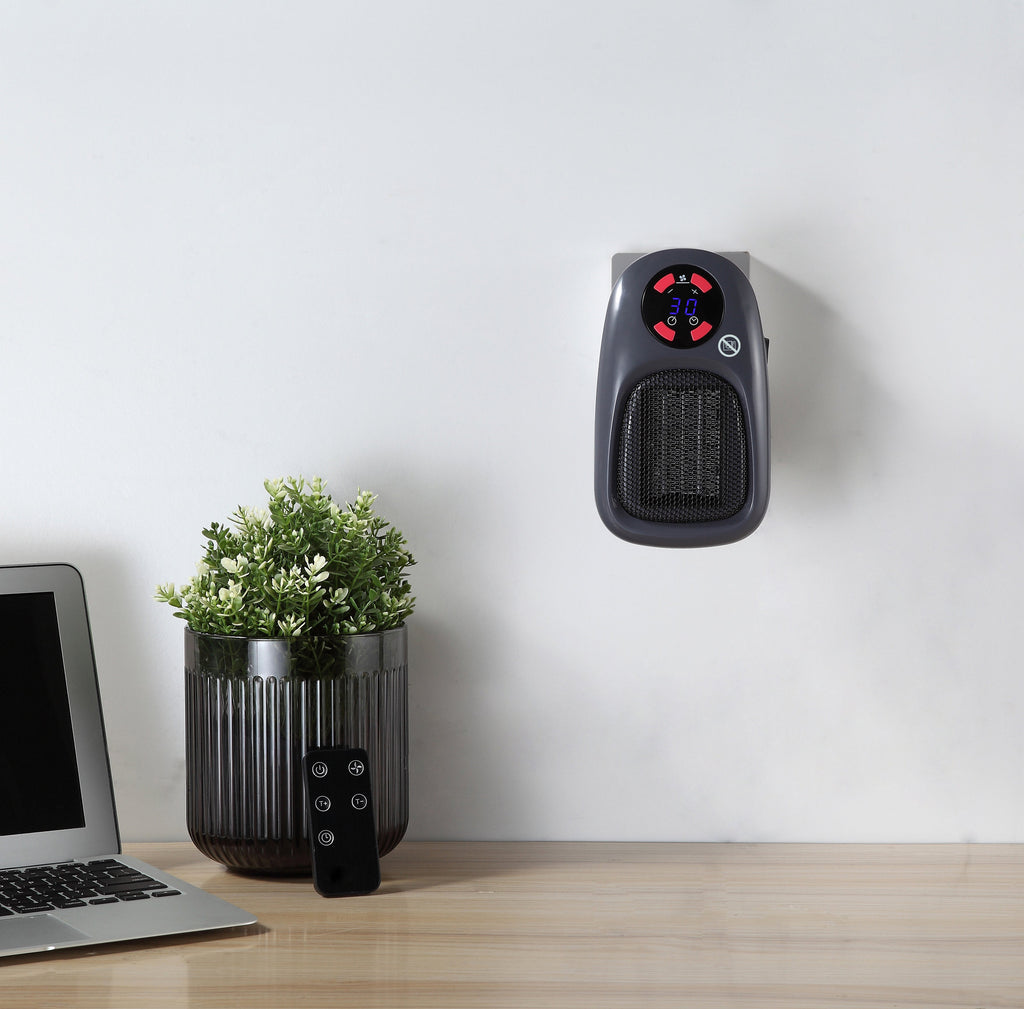 BALDERIA Plug-In Heater SH500 with remote on wall, next to laptop and plant.